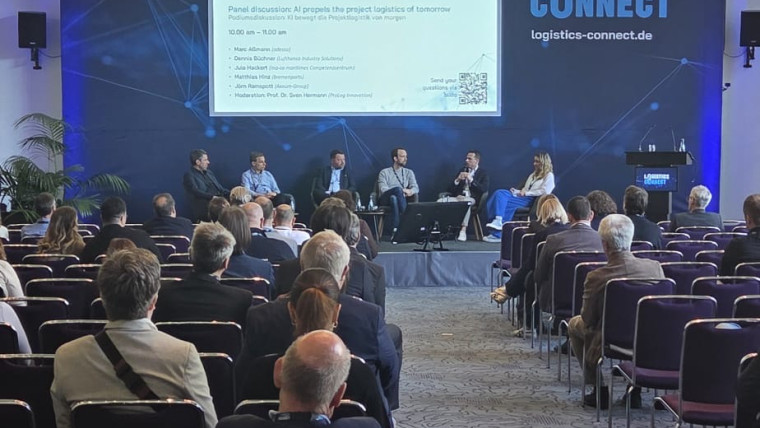 Podiumsdiskussion mit mehreren Personen vor Publikum in einem Konferenzsaal mit großem Bildschirm und Banner LOGISTICS CONNECT