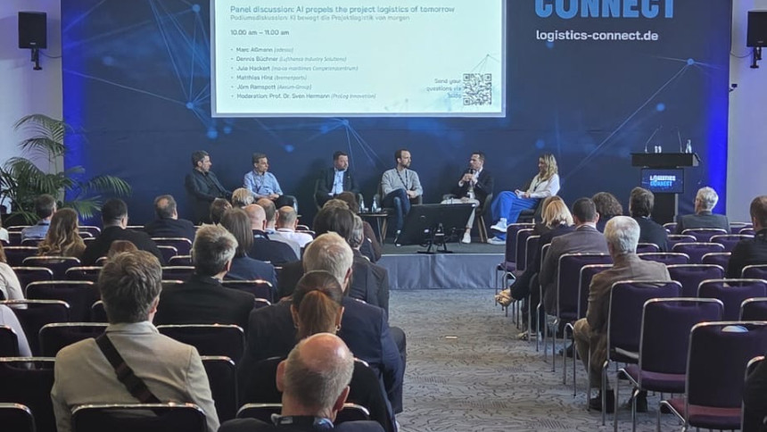 Podiumsdiskussion mit mehreren Personen vor Publikum in einem Konferenzsaal mit großem Bildschirm und Banner LOGISTICS CONNECT