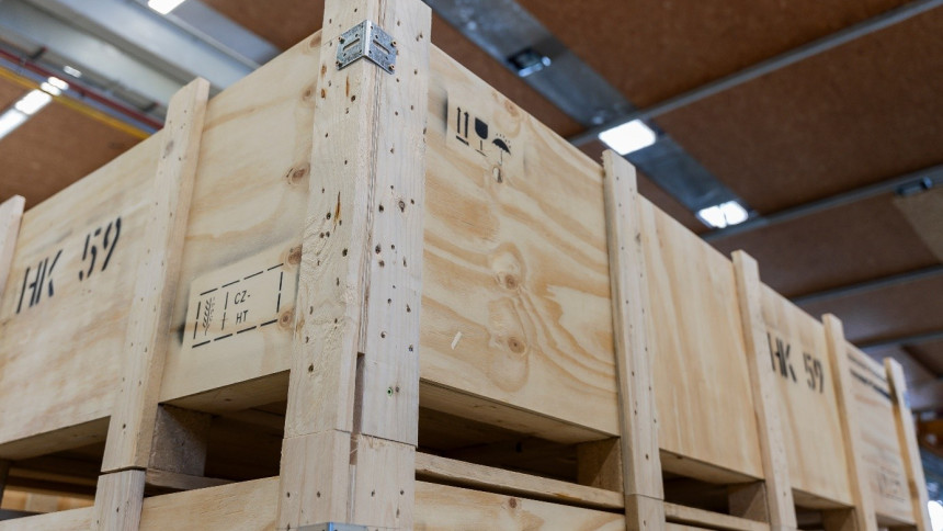 Große Holzkisten, die in einem Lagerhaus gestapelt sind, mit sichtbaren Metallscharnieren und Markierungen