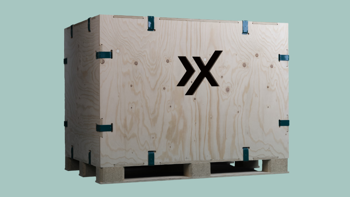 AXXUM kliXXkiste: Holzversandkiste mit blauen Metallklammern und einem schwarzen Logo an der Seite,