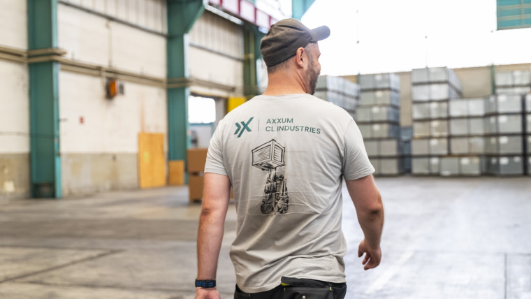 Ein Mann mit grauem Shirt bewegt sich durch ein Lager.