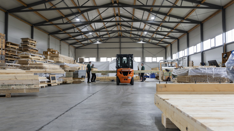 Ein Lagerhaus voller Holzstapel, die ordentlich gestapelt und bereit zur Verwendung sind.